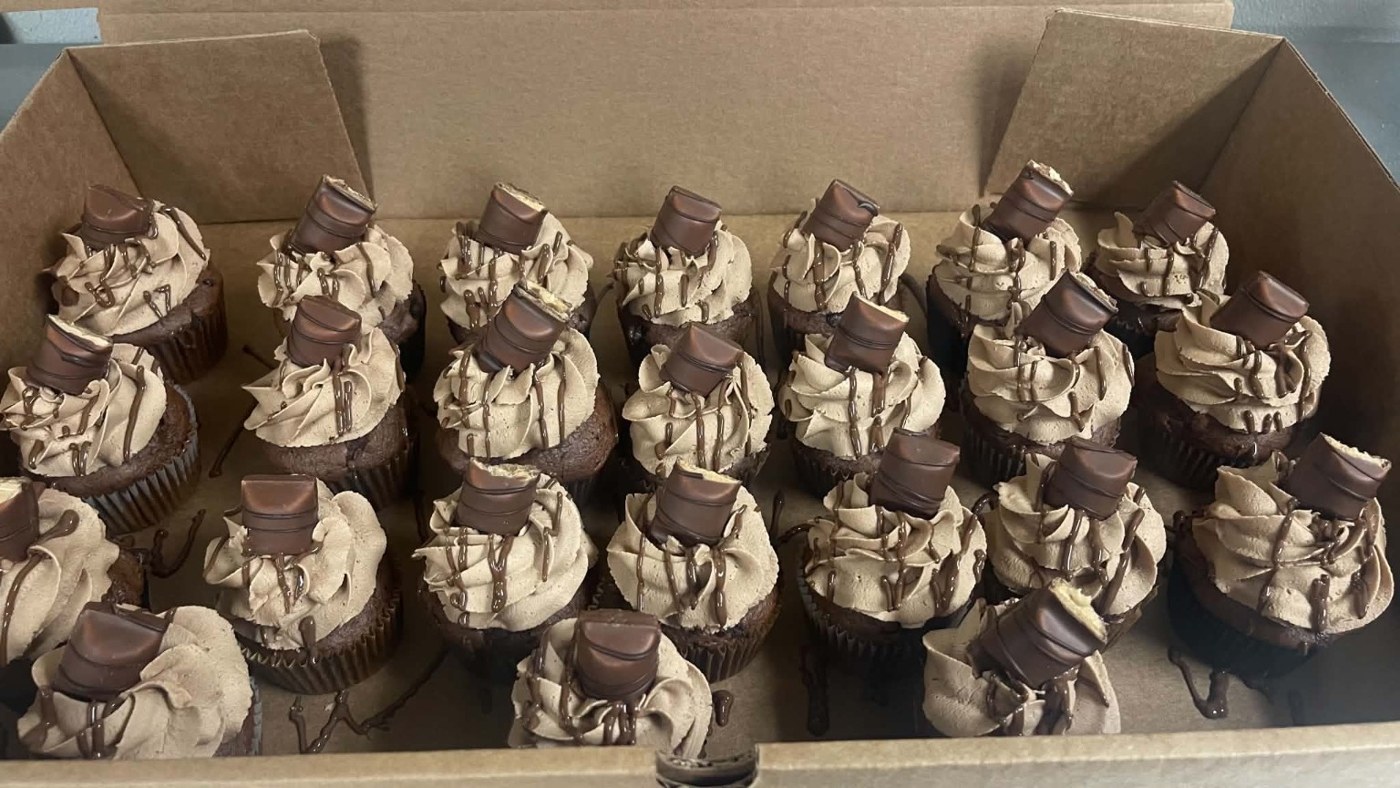 Chocolate cupcakes with piped frosting and chocolate pieces