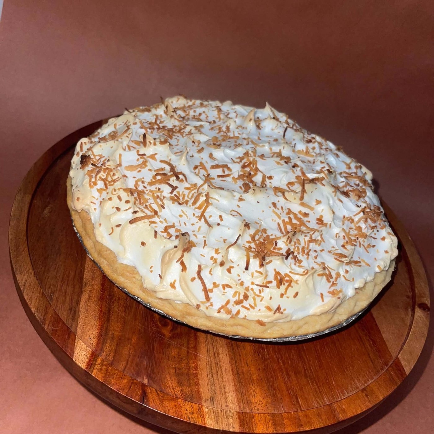 A pie with a fluffy white topping and toasted coconut